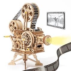 A wooden mechanical film projector with gears, reels, and a beam of light projecting film strips, used for movie projection and film viewing.