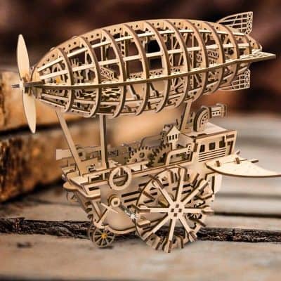 Detailed wooden airship model with intricate gears and structures, perfect for steampunk enthusiasts and artistic decor. Handcrafted, showcasing expert woodworking skills.