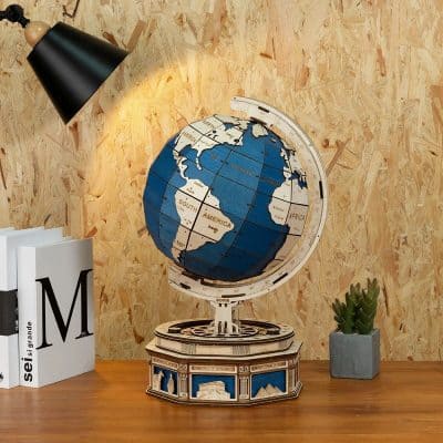 Decorative globe on wooden desk with books and potted plant, ideal for modern home or office decor, showcasing world geography, educational and stylish.