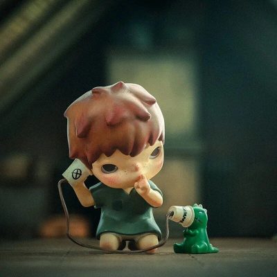 Adorable kid figurine holding a vintage phone with a small green dinosaur, perfect for collectible displays and adding charm to your home or office decor.