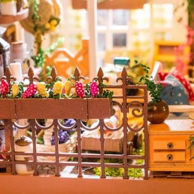 Decorative opt shop display with colorful flowers and cozy wooden accents for a welcoming optical retail environment.