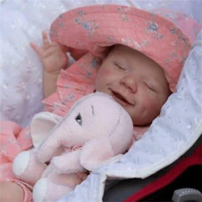 Baby sleeping peacefully with plush elephant toy, wearing floral hat, in cozy surroundings. Perfect for infants' comfort and adorable nursery decor.