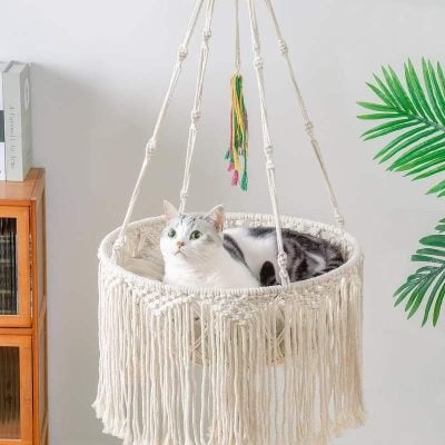 Optical cat hammock with macrame design, perfect for cozy lounging and soothing your feline friend. Ideal for stylish pet owners seeking comfortable and decorative cat furniture.
