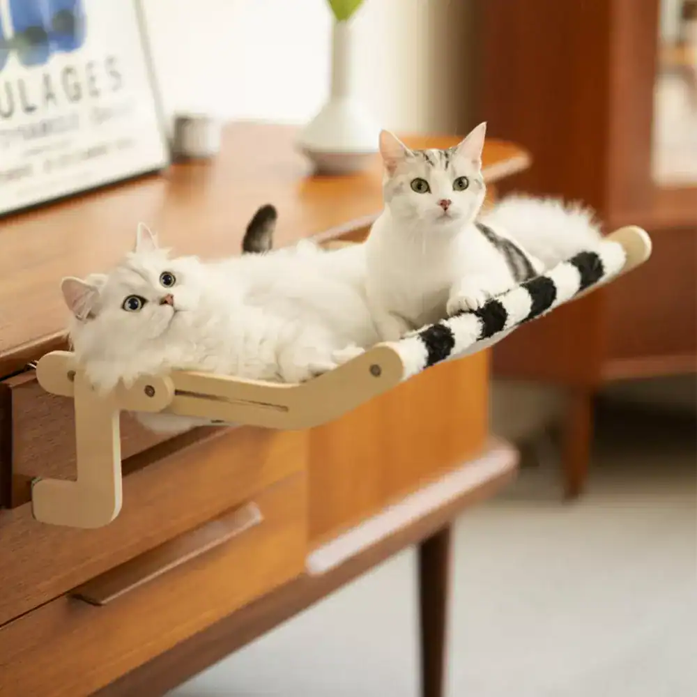 Cats lounging on a cozy window perch with plush black and white fabric, perfect for pet lovers seeking comfortable and decorative cat furniture for home decor.