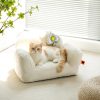 Comfortable white pet bed with a fluffy cat relaxing on it in a bright, modern room with natural light and plants.