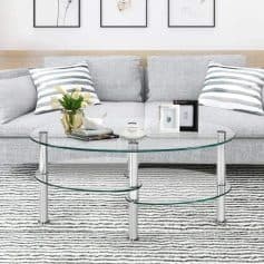 Elegant gray sofa with striped pillows, complemented by a stylish glass coffee table, floral decor, and framed artwork, creating a cozy and contemporary living room vibe.