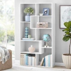 A stylish white bookshelf with decorative items, books, and a globe, showcasing the ambiance of Monalisa Medical's optical store with modern design and eye care accessories.