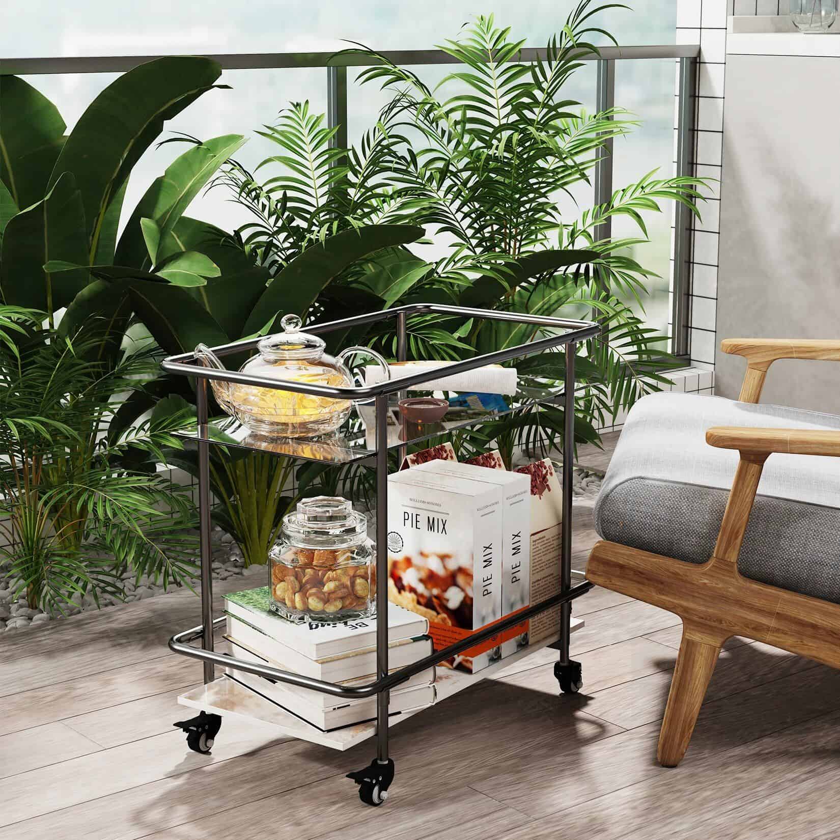 Stylish metal medical trolley with health supplements, books, and tea set beside lush green plants for a welcoming healthcare environment.