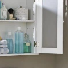 A white bathroom cabinet with skincare, towels, and decorative essentials, perfect for organizing beauty products and maintaining a tidy, efficient skincare routine.