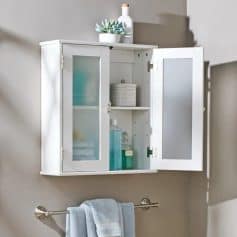 A white bathroom wall cabinet with frosted glass doors, storing toiletries, skincare, and decorative items, ideal for organizing your bathroom essentials efficiently.