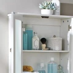 Bright white optician storage cabinet with skincare and contact lens accessories.