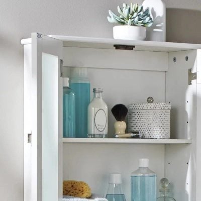 Bright white optician storage cabinet with skincare and contact lens accessories.