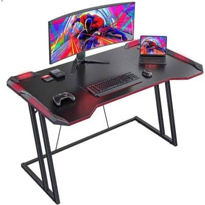 Stylish gaming desk with large monitor, gaming accessories, and ergonomic setup for optimal workspace and gaming performance.