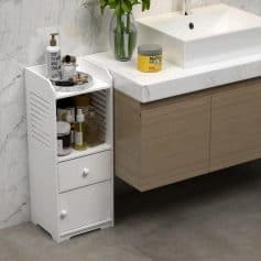 A modern bathroom scene featuring a white, multi-tiered storage cart filled with skincare essentials, placed beside a marble-topped vanity with a sleek sink, emphasizing organization and style.