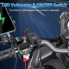 Alt text: Close-up of a motorcycle handlebars with a built-in LED voltmeter and USB adapter, highlighting the easy-to-read display and charging capabilities for electric scooter and bike maintenance.
