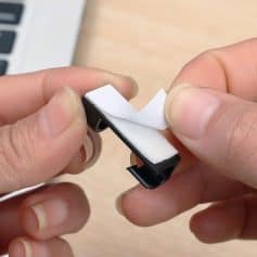 A person holding a contact lens wipe cleaning cloth for eye care and hygiene. Includes a small storage case, ideal for maintaining clear vision and eye health.