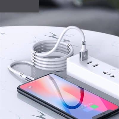 High-quality charging cable connected to power outlet with smartphone charging on clean marble surface.