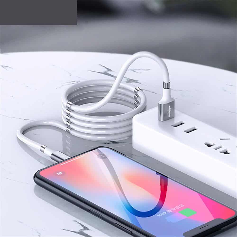 High-quality charging cable connected to power outlet with smartphone charging on clean marble surface.