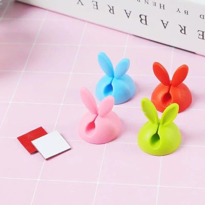 Fun and vibrant bunny-shaped earphone holders in pink, blue, green, and orange, perfect for organizing and protecting your earbuds while adding a playful touch to your desk or travel accessories.