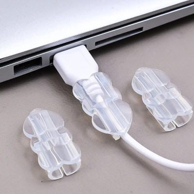 Transparent cable clips for laptop cords, preventing tangling and damage. Easy to attach and remove, suitable for organizing charging cables and data cords for a clean workspace.