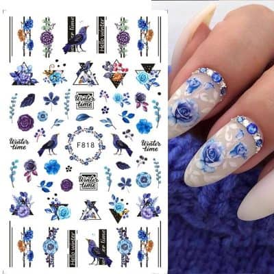 Beautiful blue floral nail art with rhinestones and intricate design, perfect for winter season manicures. Includes floral accents and winter-themed decorations for stylish nails.