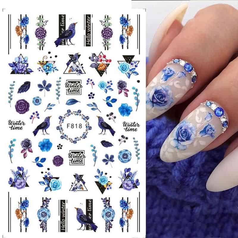 Beautiful blue floral nail art with rhinestones and intricate design, perfect for winter season manicures. Includes floral accents and winter-themed decorations for stylish nails.