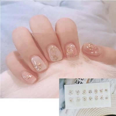 Delicate nail design featuring celestial-themed gold foil accents and star-shaped embellishments for a trendy, elegant look. Perfect for special occasions or everyday style.