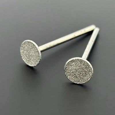 Close-up of sparkling diamond stud earrings with a sleek, modern design, perfect for stylish women and men. Crafted for elegance and durability, ideal for special occasions or everyday wear.