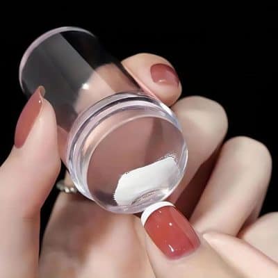 Close-up of a hand holding a small transparent container with white powder, used for nail health and beauty, showcasing premium nail care products available at Monalisa Store.