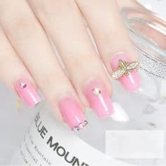 Elegant pink nail design with rhinestones and 3D bee embellishment, perfect for enhancing your look with trendy nail art accessories.
