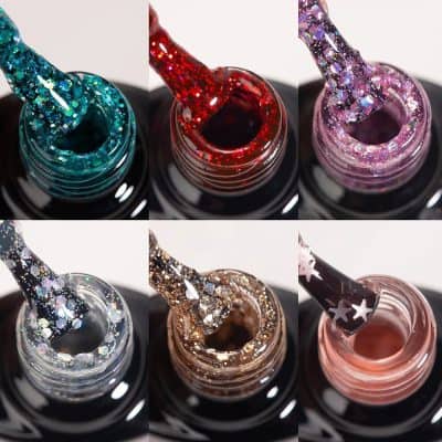 Close-up of colorful glitter nail polishes with applicators, showcasing sparkly, shimmering finishes perfect for stylish nails and beauty enhancement.
