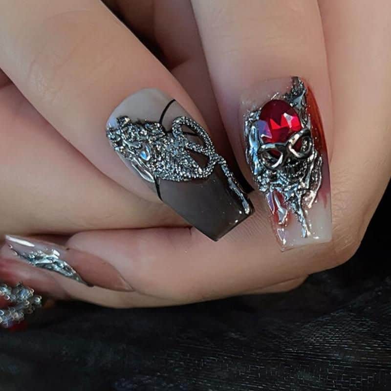Highly detailed and glamorous nail art featuring intricate silver embellishments and 3D adornments on both black and red backgrounds, perfect for fashion-forward and stylish individuals.