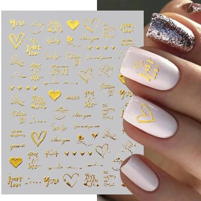 Elegant nail art with gold love-themed decals on pastel pink and glitter designs. Perfect for romantic occasions or stylish everyday looks. High-quality salon-quality manicure essentials.