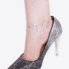 Elegant silver glitter high heel shoe paired with a diamond-studded ankle bracelet spelling out "LIT". Perfect for chic occasions, combining fashionable footwear with eye-catching jewelry.