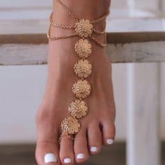 Close-up of a gold ankle bracelet and toe rings adorned with gold coins, perfect forenhancing your stylish look. Ideal for jewelry enthusiasts seeking unique, high-quality ankle accessories.