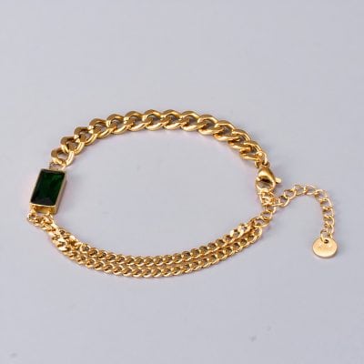 Close-up of luxurious gold chain bracelet featuring a striking green gemstone on a plain background. Perfect for fashionable accessories and jewelry shopping at Monalisa Store.