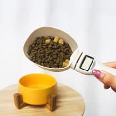 Digital pet food scale measuring dog food pellets for exact feeding portions.