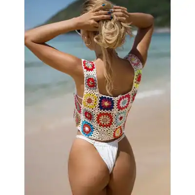 A colorful, hand-crocheted beach top with floral granny squares, perfect for summer beachwear and stylish sun protection.