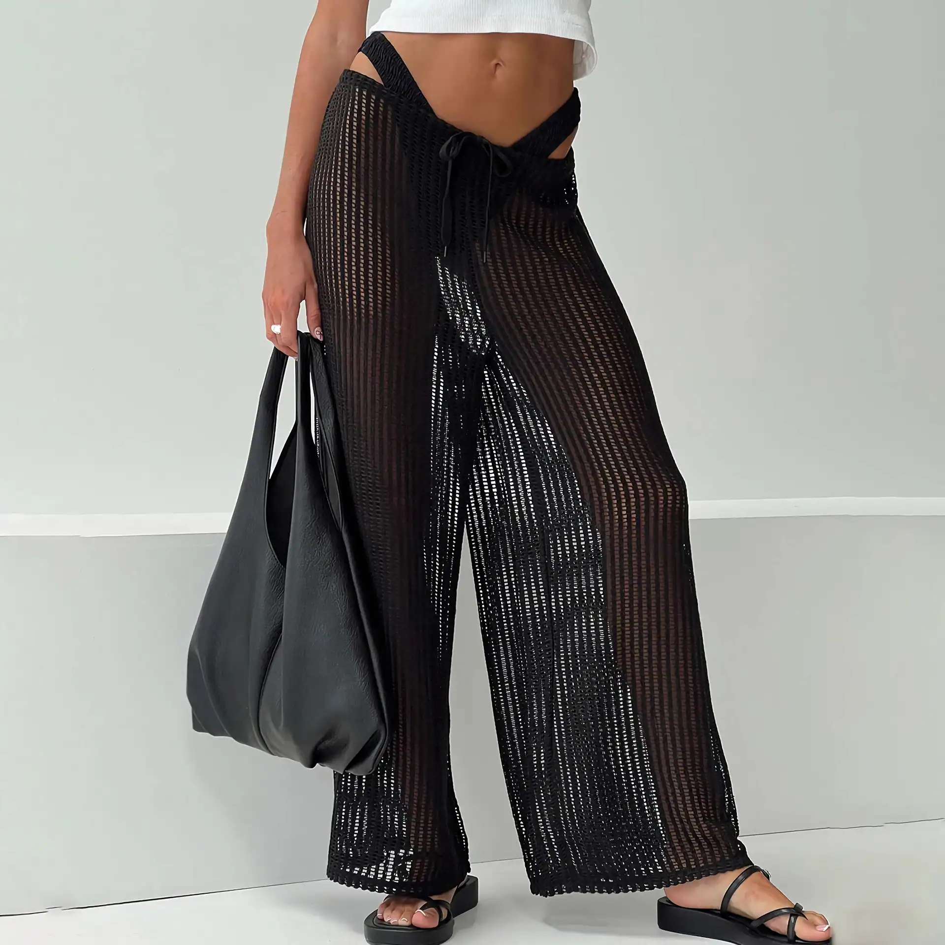 Stylish black mesh cover-up pants, perfect for beachwear or poolside fashion, featuring a drawstring waistband and wide-leg design for comfort and style.