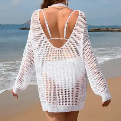 Elegant white crochet beach cover-up over bikini on woman at the beach, perfect for summer vacations, stylish swimwear, and beach fashion.