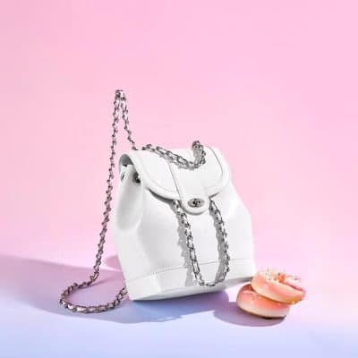 Elegant white handbag with silver chain strap on soft pastel background. Perfect accessory for fashion-forward styles, blending luxury and modern elegance.