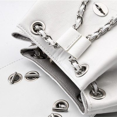 Elegant white handbag with silver chain strap and grommet details, perfect for stylish accessories and fashion-forward looks. A must-have for modern women seeking sophistication.