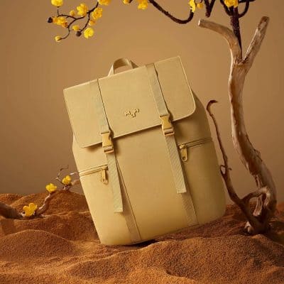 Optical shop display features a trendy beige backpack with multiple zippered pockets, ideal for stylish outings and everyday carry needs.