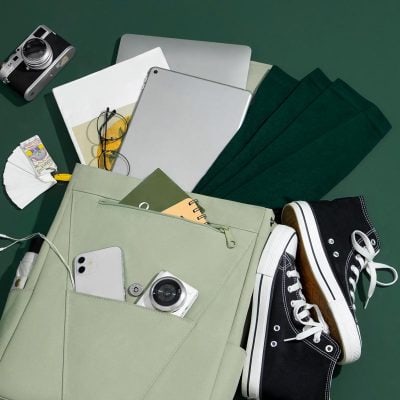 A modern workspace featuring laptops, a camera, eyeglasses, notebooks, and sneakers, perfect for eyewear shopping and optical accessories at Monalisa Store.