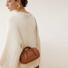 Luxurious cream knit sweater paired with a stylish woven leather crossbody bag, perfect for a chic, casual look. Ideal for fall fashion, comfort, and versatile style.
