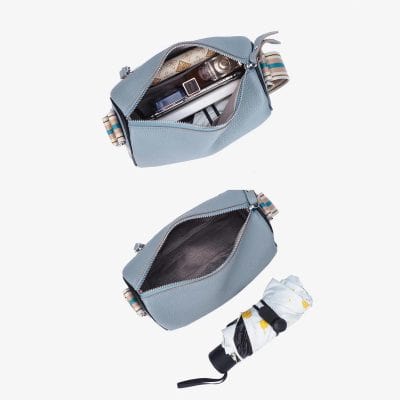 Close-up of a light blue women's crossbody bag with contents inside, including cosmetics and personal items, highlighting stylish and functional accessories for women.