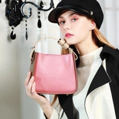 Young woman holding pink handbag and wearing black stylish hat, casual chic outfit, perfect for fashion-forward shopping or outings.