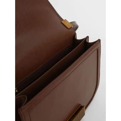 Close-up of a stylish brown leather handbag with gold accents, multiple compartments, and premium craftsmanship, ideal for professional or casual use.