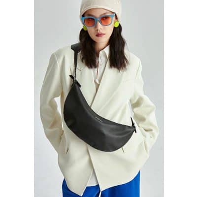 Young woman wearing trendy sunglasses, colorful earrings, and a fashionable tote. Perfect for fashion-forward individuals seeking stylish eye wear and accessories.