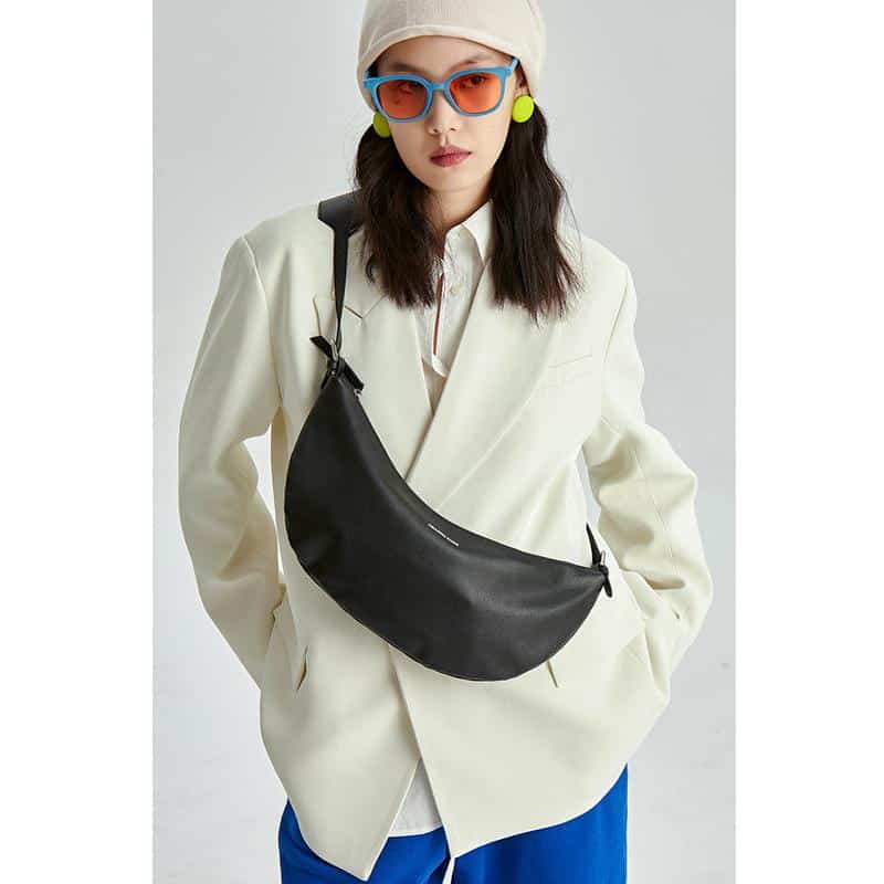 Young woman wearing trendy sunglasses, colorful earrings, and a fashionable tote. Perfect for fashion-forward individuals seeking stylish eye wear and accessories.